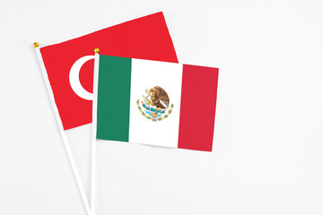 Mexico and Turkey stick flags on white background. High quality fabric, miniature national flag. Peaceful global concept.White floor for copy space.