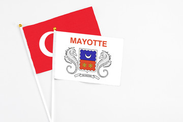 Mayotte and Turkey stick flags on white background. High quality fabric, miniature national flag. Peaceful global concept.White floor for copy space.