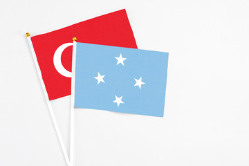Micronesia and Turkey stick flags on white background. High quality fabric, miniature national flag. Peaceful global concept.White floor for copy space.