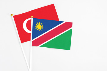 Namibia and Turkey stick flags on white background. High quality fabric, miniature national flag. Peaceful global concept.White floor for copy space.