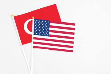 United States and Turkey stick flags on white background. High quality fabric, miniature national flag. Peaceful global concept.White floor for copy space.