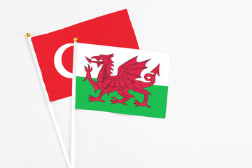 Wales and Turkey stick flags on white background. High quality fabric, miniature national flag. Peaceful global concept.White floor for copy space.