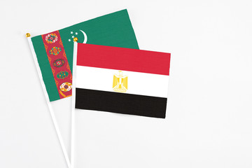 Egypt and Turkmenistan stick flags on white background. High quality fabric, miniature national flag. Peaceful global concept.White floor for copy space.