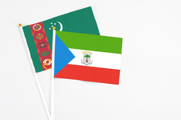 Equatorial Guinea and Turkmenistan stick flags on white background. High quality fabric, miniature national flag. Peaceful global concept.White floor for copy space.