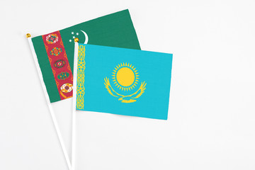 Kazakhstan and Turkmenistan stick flags on white background. High quality fabric, miniature national flag. Peaceful global concept.White floor for copy space.