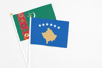Kosovo and Turkmenistan stick flags on white background. High quality fabric, miniature national flag. Peaceful global concept.White floor for copy space.