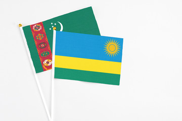 Rwanda and Turkmenistan stick flags on white background. High quality fabric, miniature national flag. Peaceful global concept.White floor for copy space.