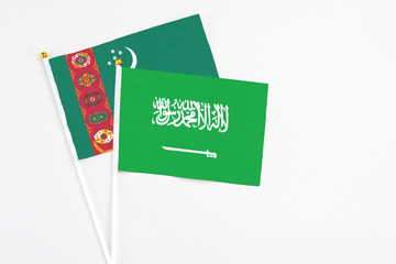 Saudi Arabia and Turkmenistan stick flags on white background. High quality fabric, miniature national flag. Peaceful global concept.White floor for copy space.