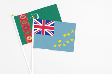 Fototapeta premium Tuvalu and Turkmenistan stick flags on white background. High quality fabric, miniature national flag. Peaceful global concept.White floor for copy space.