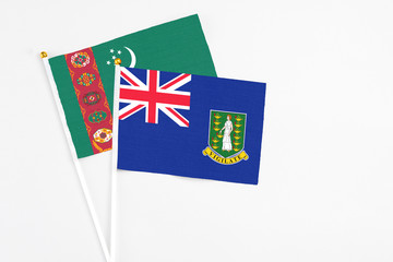 Fototapeta premium British Virgin Islands and Turkmenistan stick flags on white background. High quality fabric, miniature national flag. Peaceful global concept.White floor for copy space.