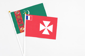Wallis And Futuna and Turkmenistan stick flags on white background. High quality fabric, miniature national flag. Peaceful global concept.White floor for copy space.