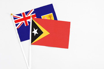 East Timor and Turks And Caicos Islands stick flags on white background. High quality fabric, miniature national flag. Peaceful global concept.White floor for copy space.