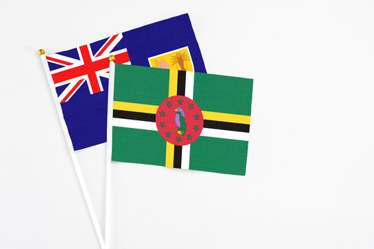 Dominica and Turks And Caicos Islands stick flags on white background. High quality fabric, miniature national flag. Peaceful global concept.White floor for copy space.
