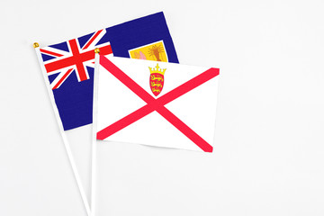 Jersey and Turks And Caicos Islands stick flags on white background. High quality fabric, miniature national flag. Peaceful global concept.White floor for copy space.
