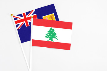 Fototapeta premium Lebanon and Turks And Caicos Islands stick flags on white background. High quality fabric, miniature national flag. Peaceful global concept.White floor for copy space.