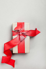 elongated gift box with a red ribbon on a gray background. blank for postcard, poster.