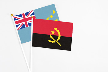 Angola and Tuvalu stick flags on white background. High quality fabric, miniature national flag. Peaceful global concept.White floor for copy space.