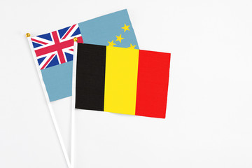 Belgium and Tuvalu stick flags on white background. High quality fabric, miniature national flag. Peaceful global concept.White floor for copy space.