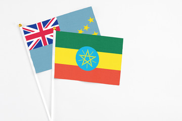 Ethiopia and Tuvalu stick flags on white background. High quality fabric, miniature national flag. Peaceful global concept.White floor for copy space.