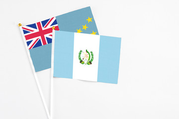 Guatemala and Tuvalu stick flags on white background. High quality fabric, miniature national flag. Peaceful global concept.White floor for copy space.