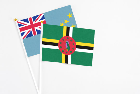 Dominica and Tuvalu stick flags on white background. High quality fabric, miniature national flag. Peaceful global concept.White floor for copy space.
