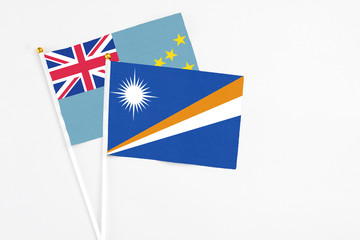 Marshall Islands and Tuvalu stick flags on white background. High quality fabric, miniature national flag. Peaceful global concept.White floor for copy space.