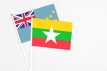 Fototapeta premium Myanmar and Tuvalu stick flags on white background. High quality fabric, miniature national flag. Peaceful global concept.White floor for copy space.