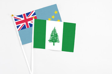 Norfolk Island and Tuvalu stick flags on white background. High quality fabric, miniature national flag. Peaceful global concept.White floor for copy space.