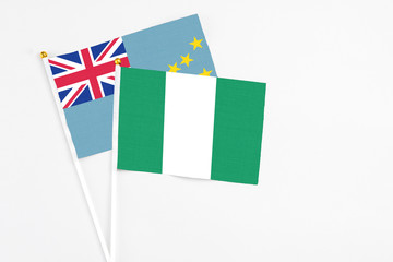 Nigeria and Tuvalu stick flags on white background. High quality fabric, miniature national flag. Peaceful global concept.White floor for copy space.