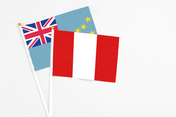 Peru and Tuvalu stick flags on white background. High quality fabric, miniature national flag. Peaceful global concept.White floor for copy space.