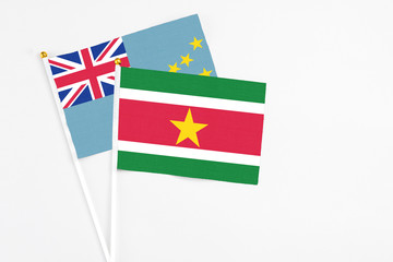 Suriname and Tuvalu stick flags on white background. High quality fabric, miniature national flag. Peaceful global concept.White floor for copy space.