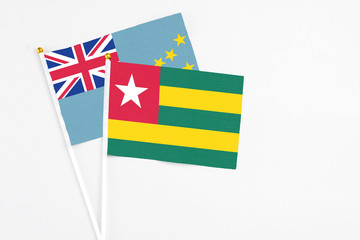 Togo and Tuvalu stick flags on white background. High quality fabric, miniature national flag. Peaceful global concept.White floor for copy space.