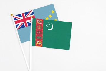 Turkmenistan and Tuvalu stick flags on white background. High quality fabric, miniature national flag. Peaceful global concept.White floor for copy space.