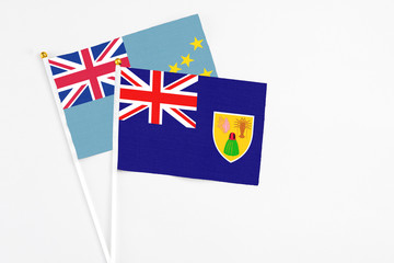 Fototapeta premium Turks And Caicos Islands and Tuvalu stick flags on white background. High quality fabric, miniature national flag. Peaceful global concept.White floor for copy space.