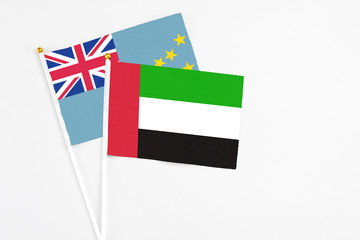 United Arab Emirates and Tuvalu stick flags on white background. High quality fabric, miniature national flag. Peaceful global concept.White floor for copy space.