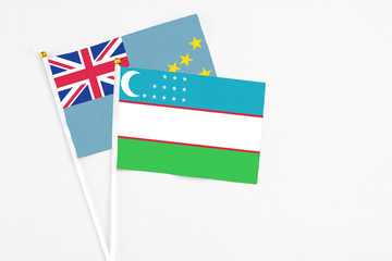 Uzbekistan and Tuvalu stick flags on white background. High quality fabric, miniature national flag. Peaceful global concept.White floor for copy space.