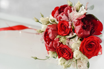 wedding bouquet of red and white flowers on a glass table