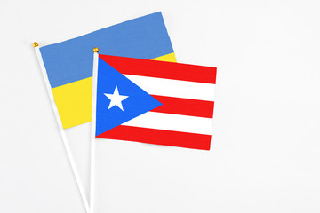 Puerto Rico and Ukraine stick flags on white background. High quality fabric, miniature national flag. Peaceful global concept.White floor for copy space.