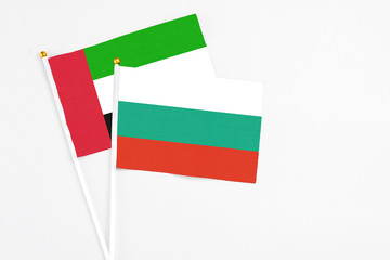 Bulgaria and United Arab Emirates stick flags on white background. High quality fabric, miniature national flag. Peaceful global concept.White floor for copy space.