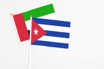 Cuba and United Arab Emirates stick flags on white background. High quality fabric, miniature national flag. Peaceful global concept.White floor for copy space.