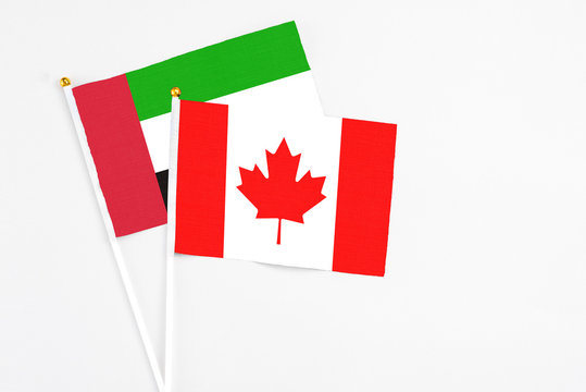 Canada and United Arab Emirates stick flags on white background. High quality fabric, miniature national flag. Peaceful global concept.White floor for copy space.