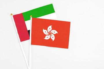 Hong Kong and United Arab Emirates stick flags on white background. High quality fabric, miniature national flag. Peaceful global concept.White floor for copy space.