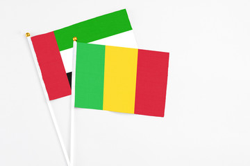 Mali and United Arab Emirates stick flags on white background. High quality fabric, miniature national flag. Peaceful global concept.White floor for copy space.