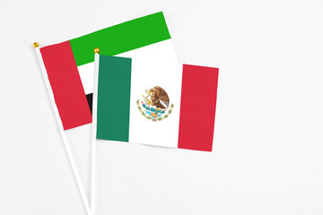 Mexico and United Arab Emirates stick flags on white background. High quality fabric, miniature national flag. Peaceful global concept.White floor for copy space.