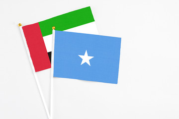 Somalia and United Arab Emirates stick flags on white background. High quality fabric, miniature national flag. Peaceful global concept.White floor for copy space.