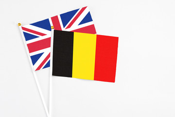 Belgium and United Kingdom stick flags on white background. High quality fabric, miniature national flag. Peaceful global concept.White floor for copy space.