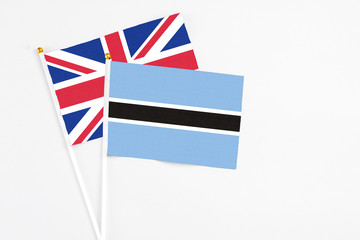 Botswana and United Kingdom stick flags on white background. High quality fabric, miniature national flag. Peaceful global concept.White floor for copy space.