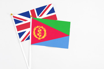 Fototapeta na wymiar Eritrea and United Kingdom stick flags on white background. High quality fabric, miniature national flag. Peaceful global concept.White floor for copy space.