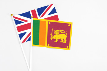 Sri Lanka and United Kingdom stick flags on white background. High quality fabric, miniature national flag. Peaceful global concept.White floor for copy space.