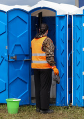 A cleaning lady cleans the toilets